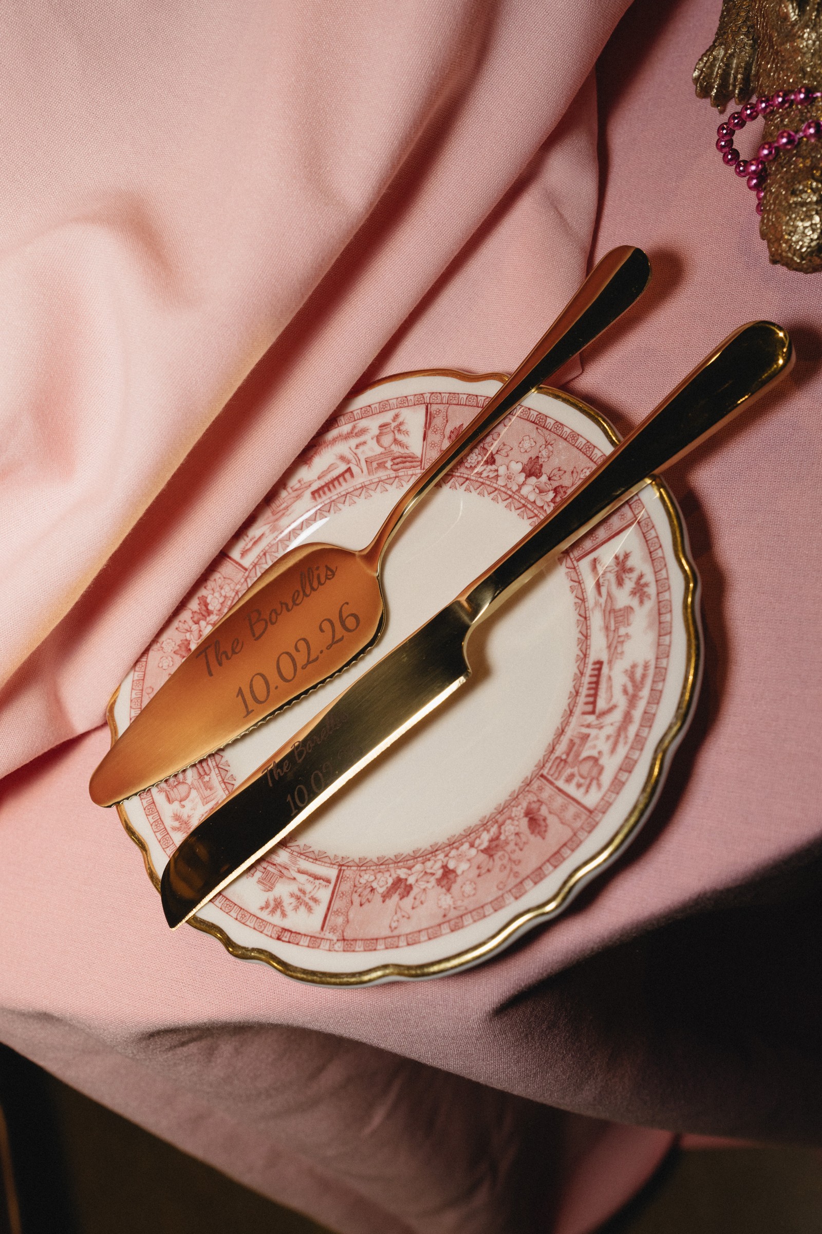 Gold cake utensils on a pink patterned plate