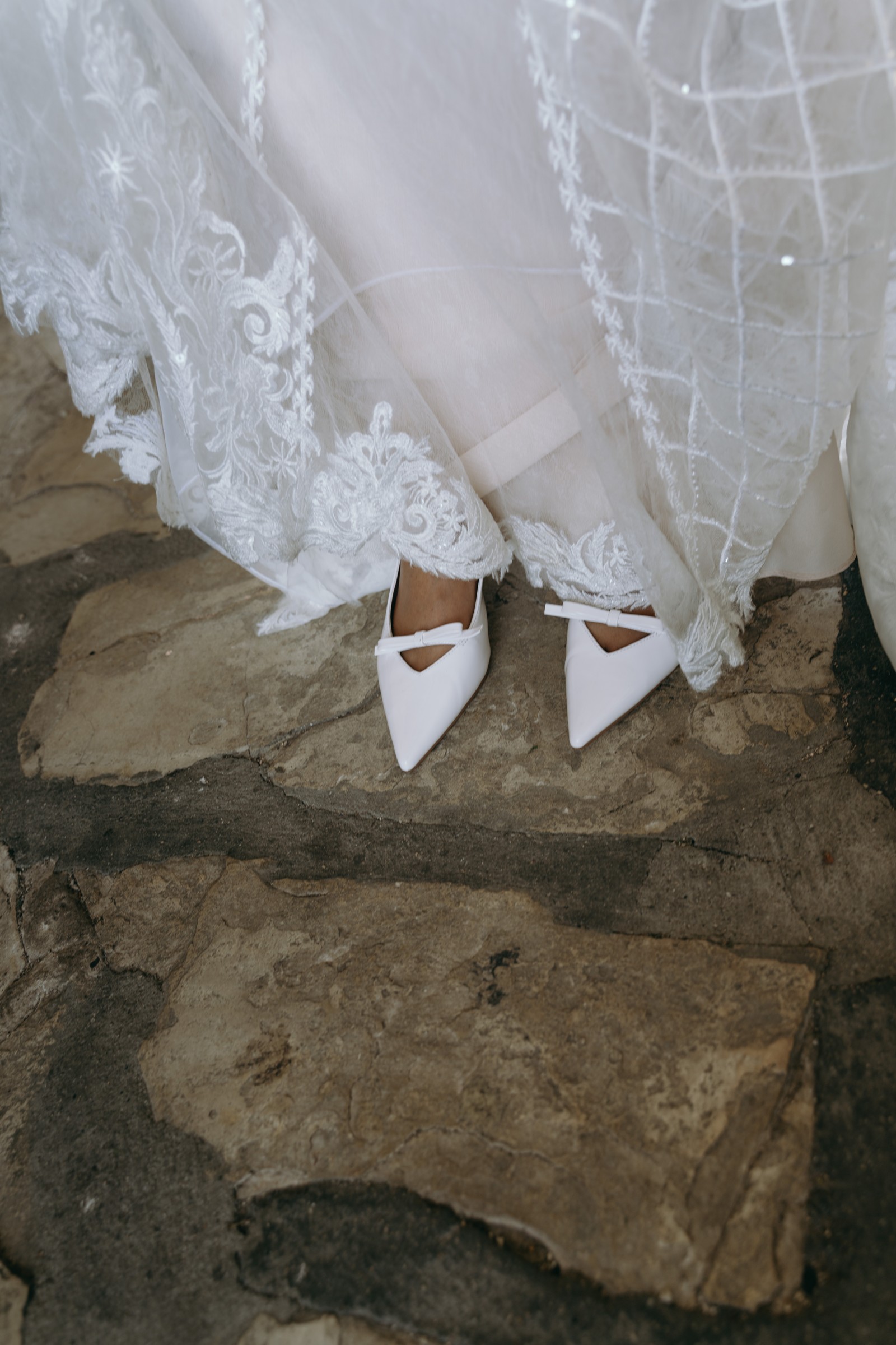 Bridal shoes beneath a lace wedding dress