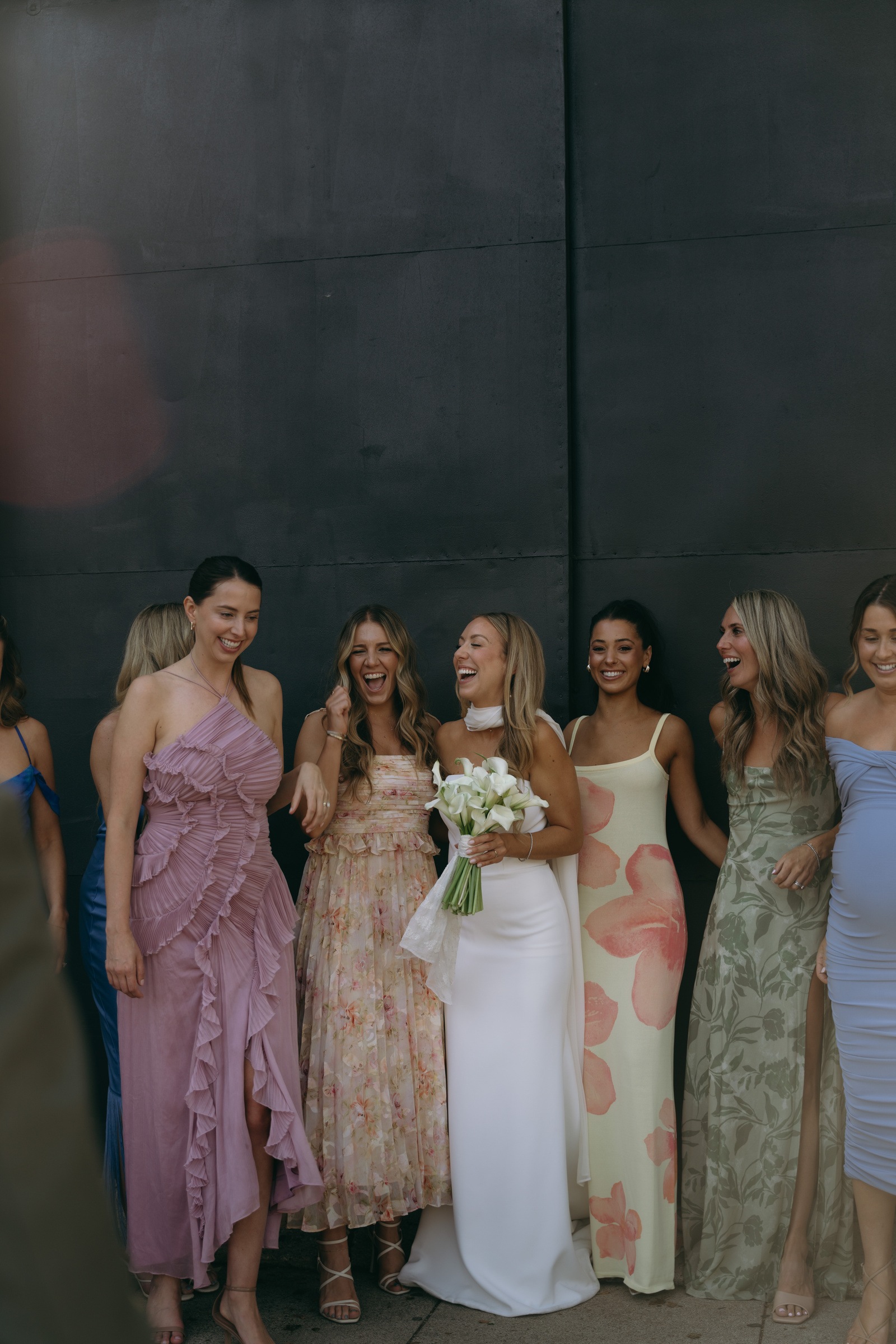 The bride laughing with her bridesmaids