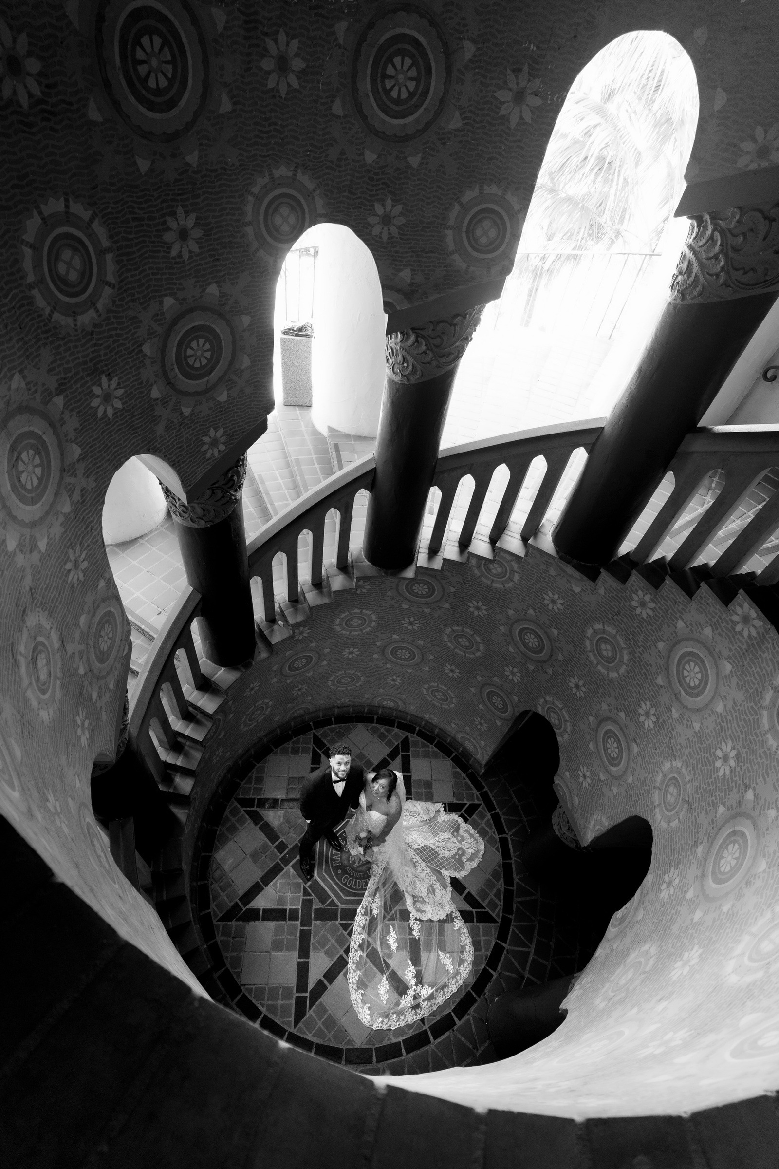 Newlyweds beneath the ornate courthouse staircase