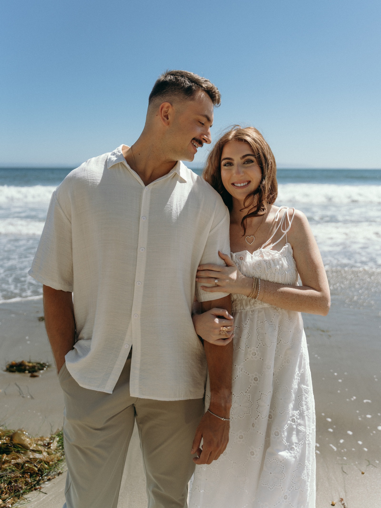 An engaged couple together beside the sea