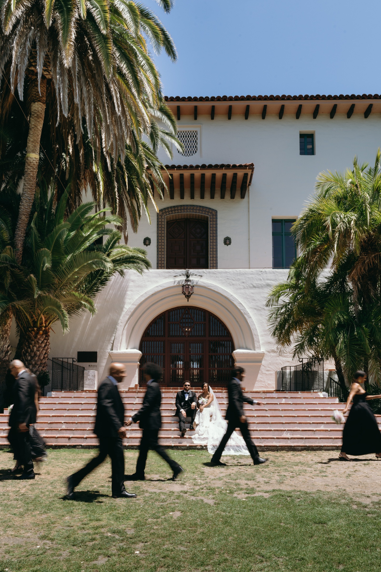 Newlyweds on the courthouse steps as guests pass by