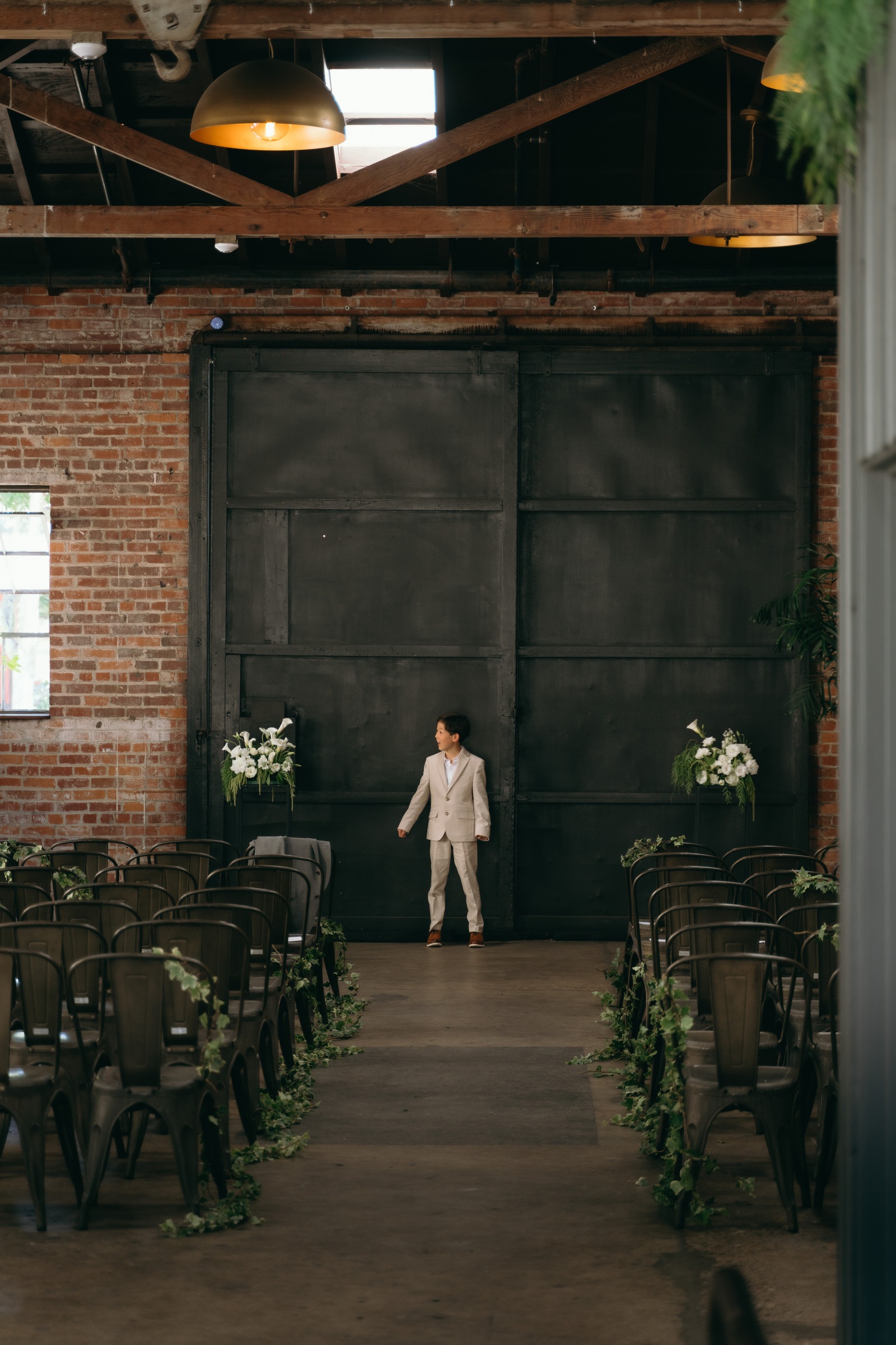 A young wedding guest in the ceremony aisle