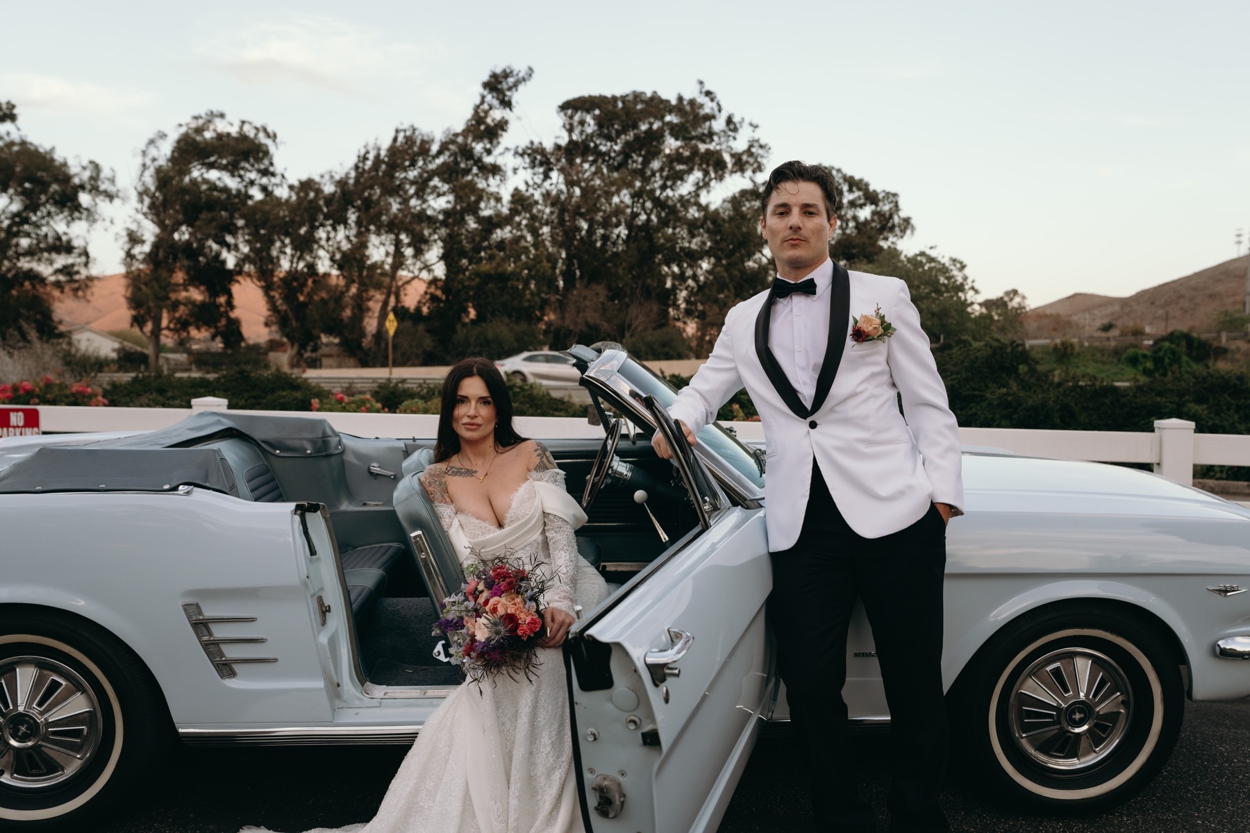 The bride and groom beside their vintage wedding car