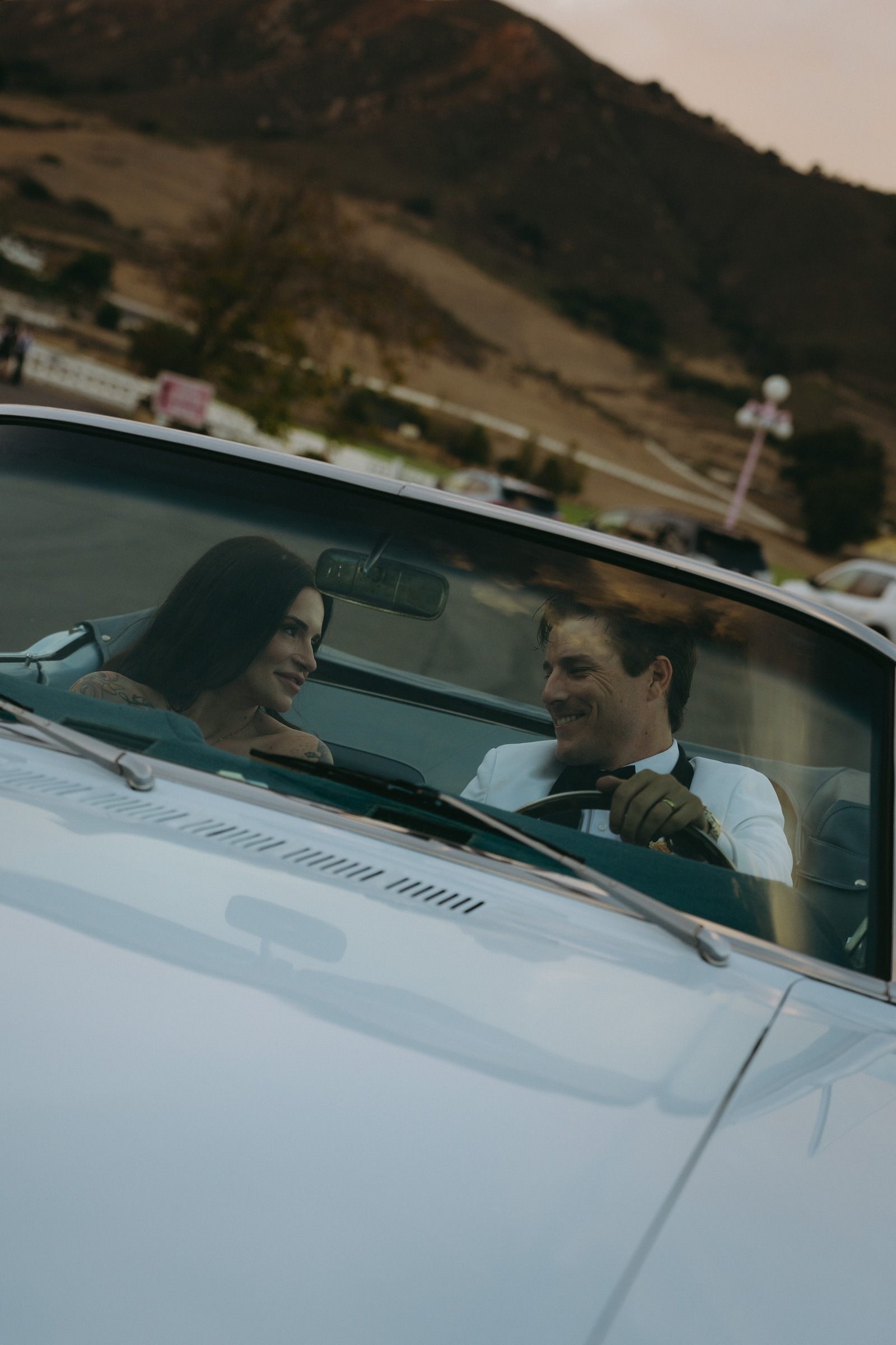 The newlyweds together in a vintage convertible