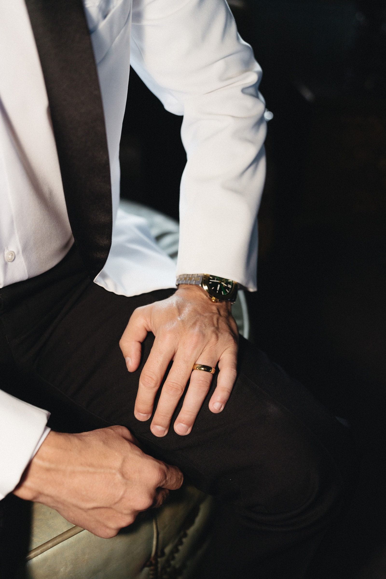 A close-up of the groom’s ring and wristwatch