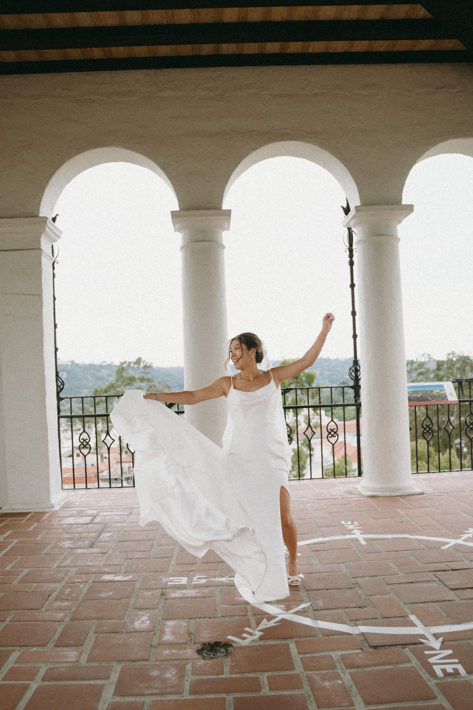 A bride twirling her dress beneath the courthouse arches